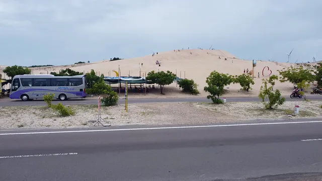 Horizontal video: Bus by sand dunes in desert landscape 28677492. Duration: 3 seconds. Resolution: 2720x1530