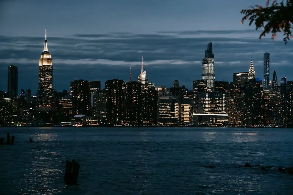 Contemporary illuminated towers located in central district on coast of rippling river in New York at night