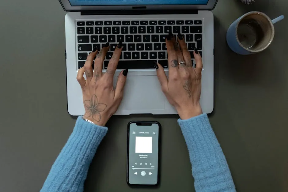 Overhead Shot of a Person Typing on a Laptop While Listening to a podcast