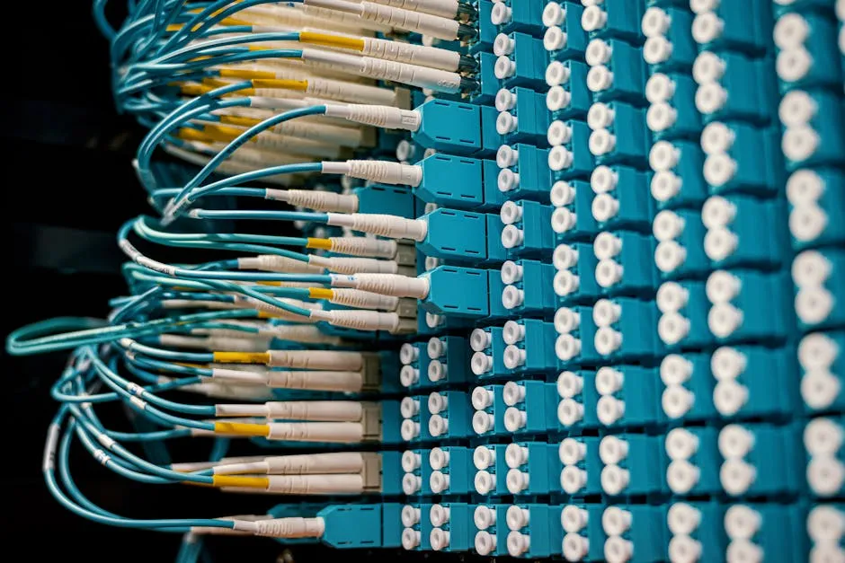 Close-up of a network patch panel with connected blue fiber optic cables.