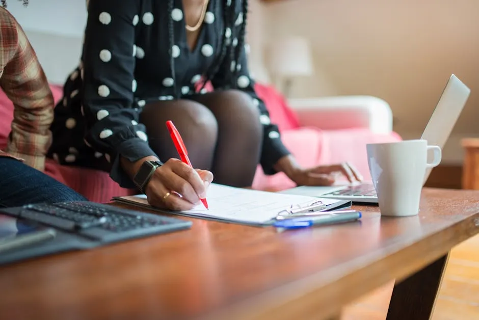 Woman Working on Laptop Writing on Paper