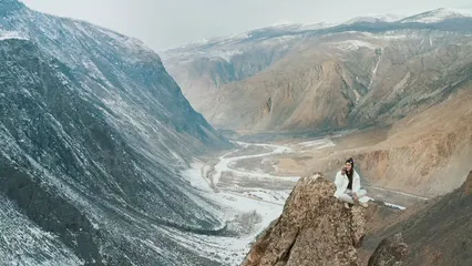 Horizontal video: Woman having a phone call while sitting on a peak 7455440. Duration: 15 seconds. Resolution: 1920x1080