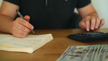 Horizontal video: A person using a calculator and taking notes 5466768. Duration: 26 seconds. Resolution: 1920x1080