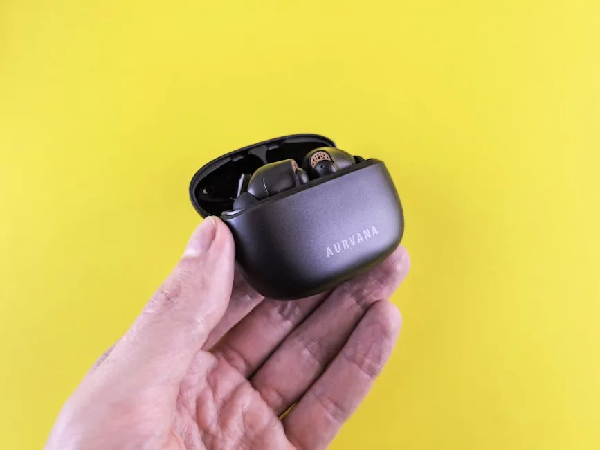 Hand Holding Wireless Earbuds Case on Yellow Background