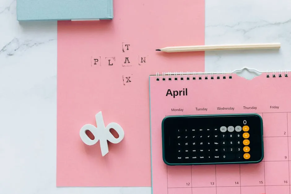 Flat lay of April calendar with calculator, pencil, and pink background for financial planning.