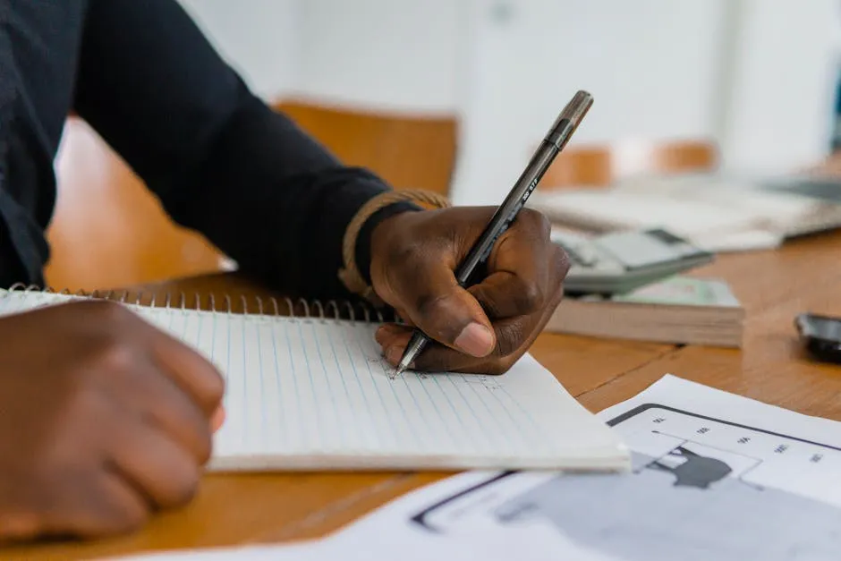 Person Writing on Notebook