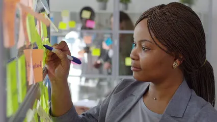 Horizontal video: A woman writing on memo pads stick on a glass panel 3195652. Duration: 16 seconds. Resolution: 3840x2160