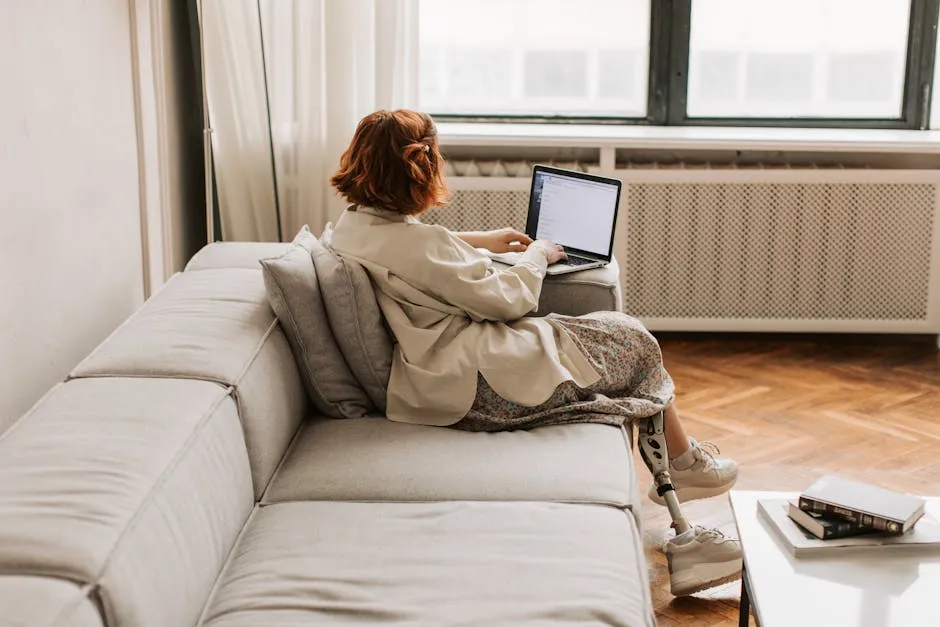 Woman sitting on a Sofa using Laptop