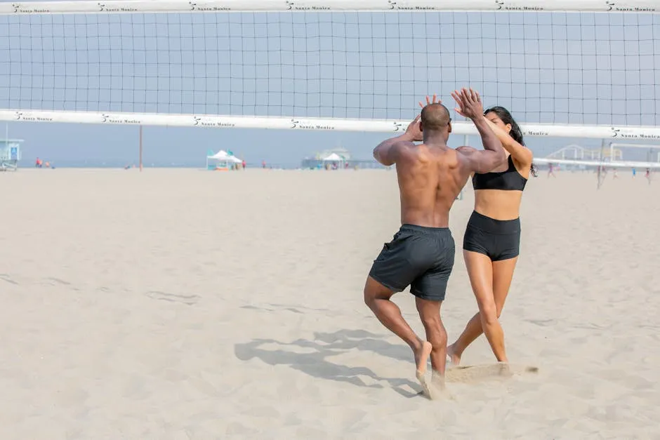 Man and Woman High-fiving while Playing Beach Volleyball