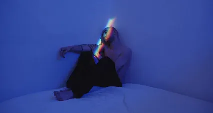 Horizontal video: A man seated on the corner of his bed in a darkroom 3712707. Duration: 16 seconds. Resolution: 4096x2160