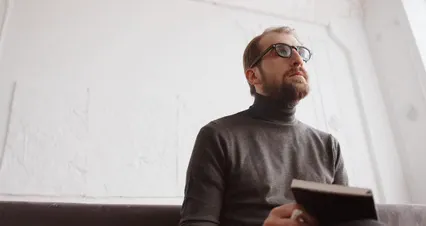 Horizontal video: A man with glasses and a beard is reading a book 4100458. Duration: 46 seconds. Resolution: 4096x2160