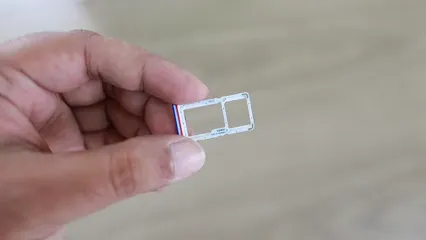 Horizontal video: A person holding a dual sim card holder slot 4201553. Duration: 17 seconds. Resolution: 1920x1080