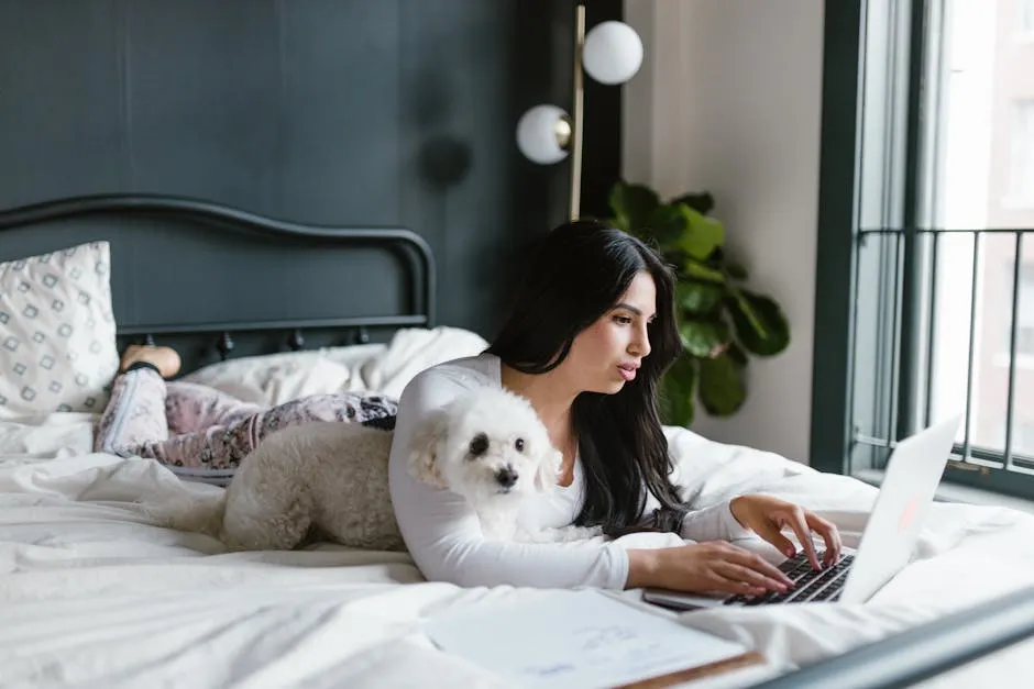 A Woman Working on the Bed With Her Dog