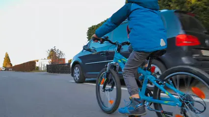 Horizontal video: A young boy riding his bike on a street inside the neighborhood 3683310. Duration: 23 seconds. Resolution: 3840x2160