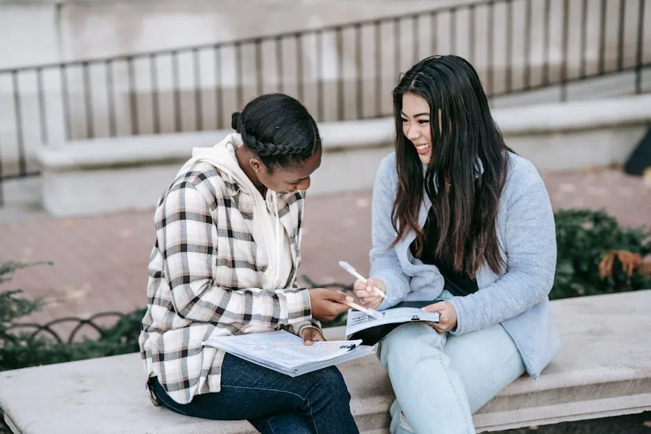 Cheerful multiethnic female students working on homework together