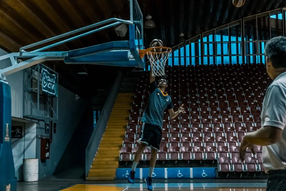 Man in Blue Shirt Trying to Dunk in Basketball Ring