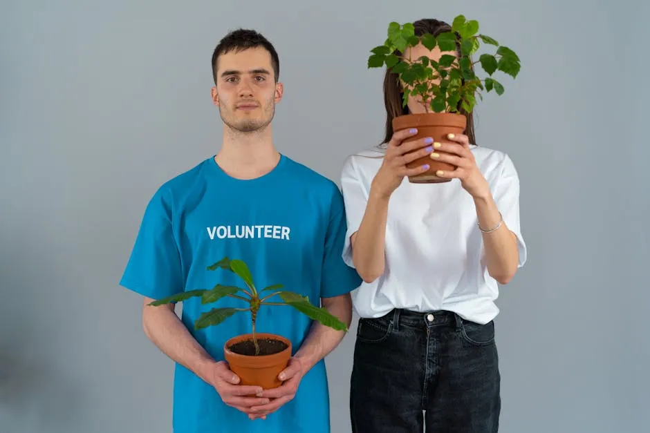 Man in Blue Crew Neck T-shirt Holding Brown Pot With Green Plant