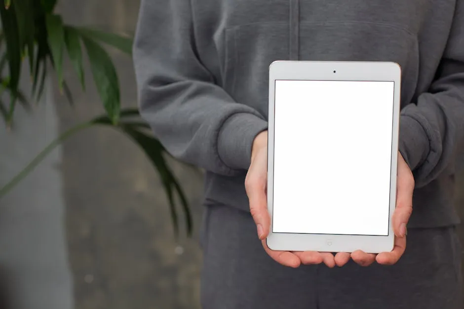 A Person in Gray Long Sleeve Shirt Holding a Tablet with Blank Screen