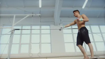 Horizontal video: A man swinging at the single bar trainers at the gym 6572842. Duration: 16 seconds. Resolution: 3840x2160