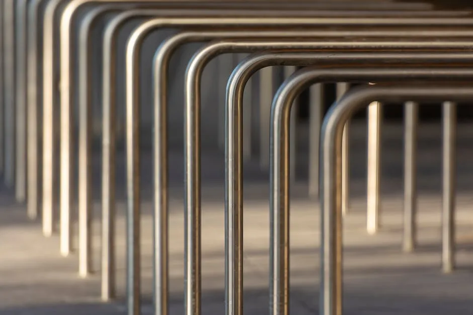 Close-up of stainless steel bike racks creating a modern, repetitive pattern.