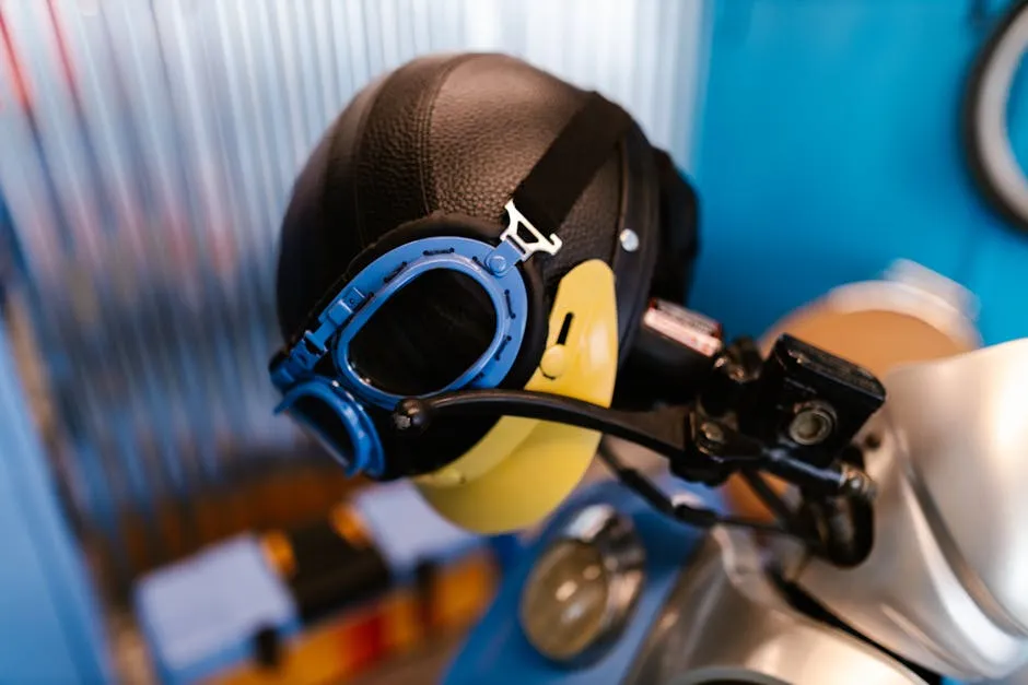 Close-up of a vintage-style motorcycle helmet and goggles on display indoors.