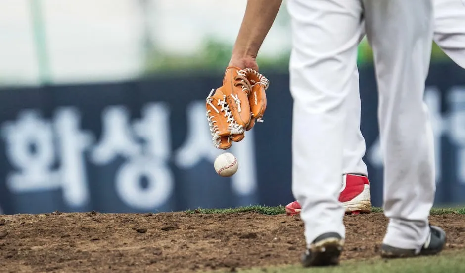 Close-up of a baseball player holding a glove ready to pitch on the field.