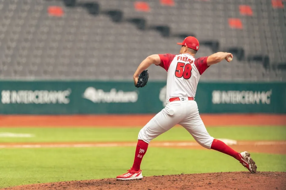 A baseball player in red and white is pitching a ball