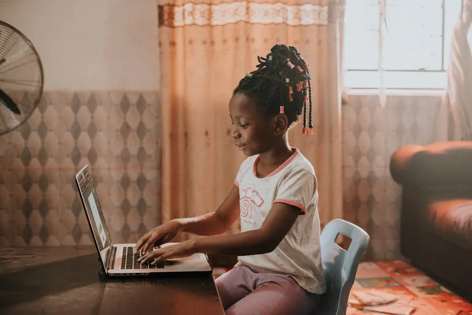 A child sitting at a desk using a laptop in a warmly lit room, showcasing modern technology and learning.