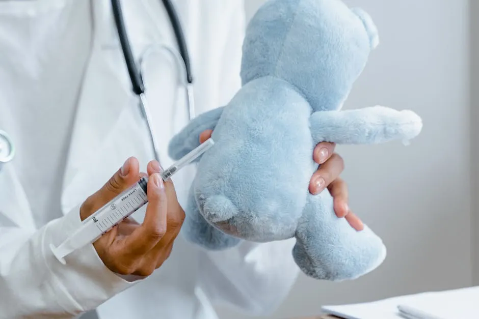 Close-up of a doctor using a syringe on a plush toy for educational purposes.