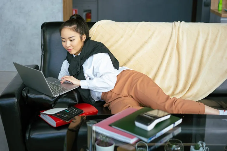 A Woman Using a Laptop while Lying Down on a Couch