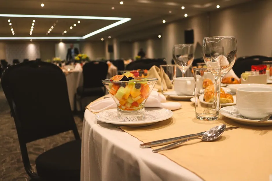 Elegant banquet table setting with fruit salad and glassware, ideal for events or weddings.